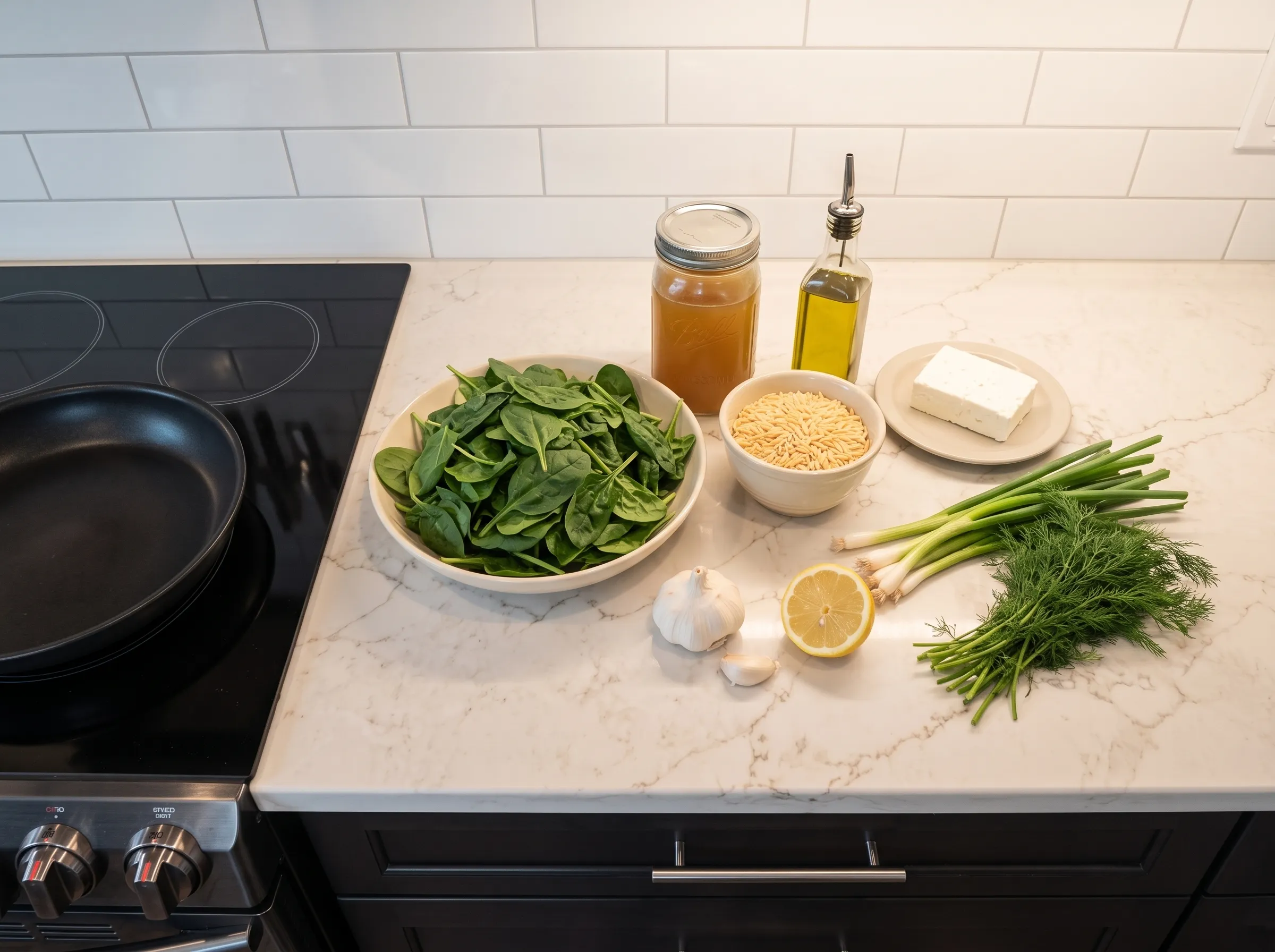 Spinach and orzo ingredients on a countertop, featuring fresh herbs, garlic, and lemon ready for cooking.